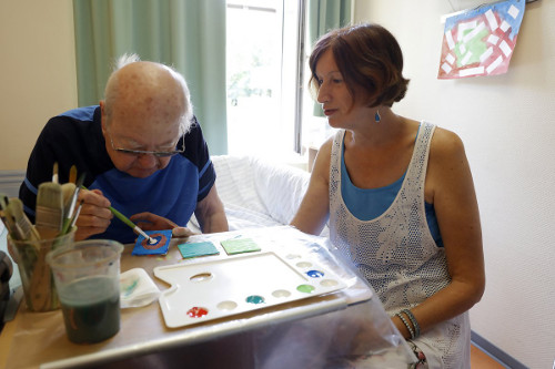 Dagmar Marth leitet einen Palliativpatienten beim Malen an.