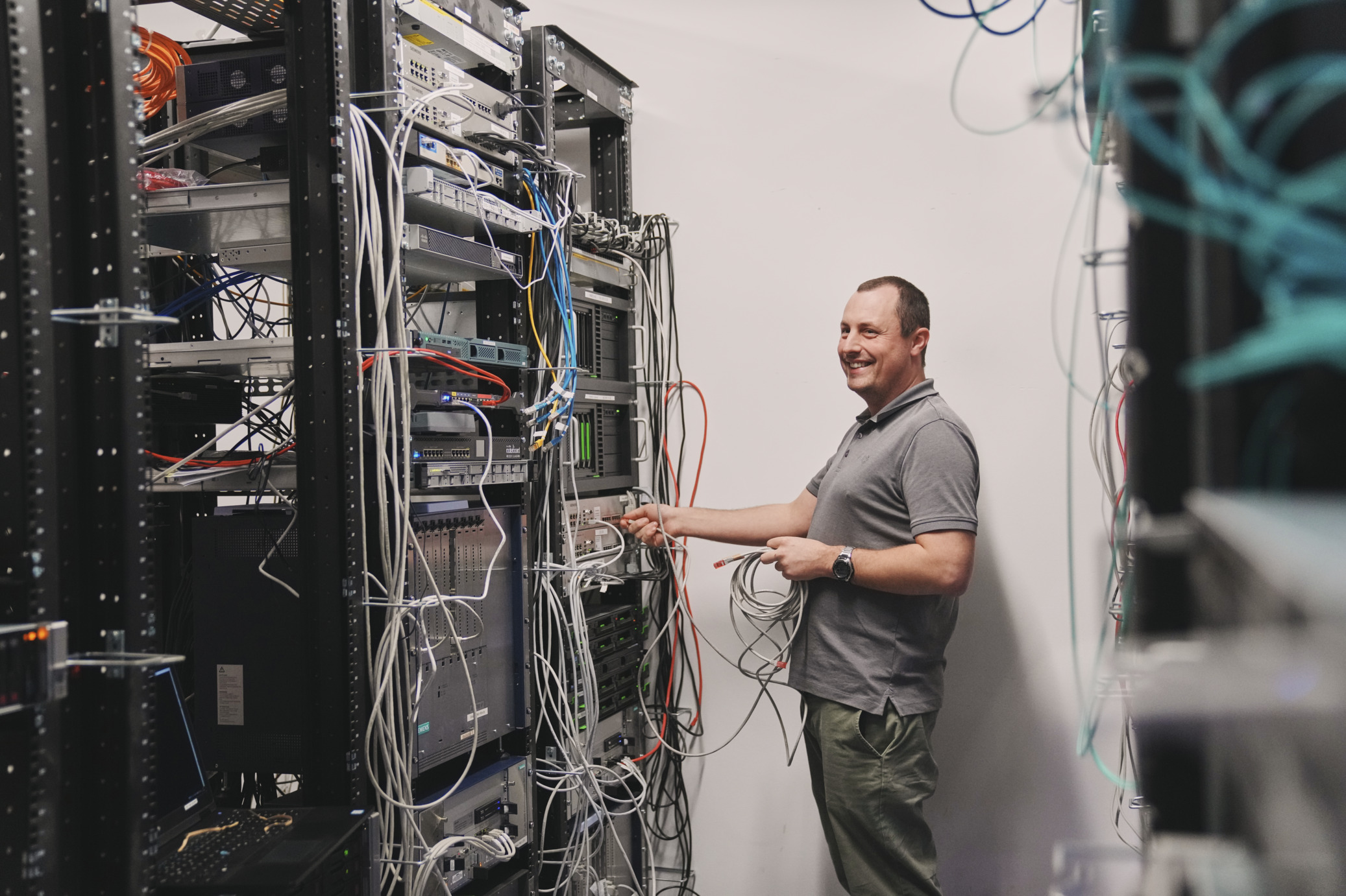 IT Mitarbeiter überprüft Kabel im Serverraum