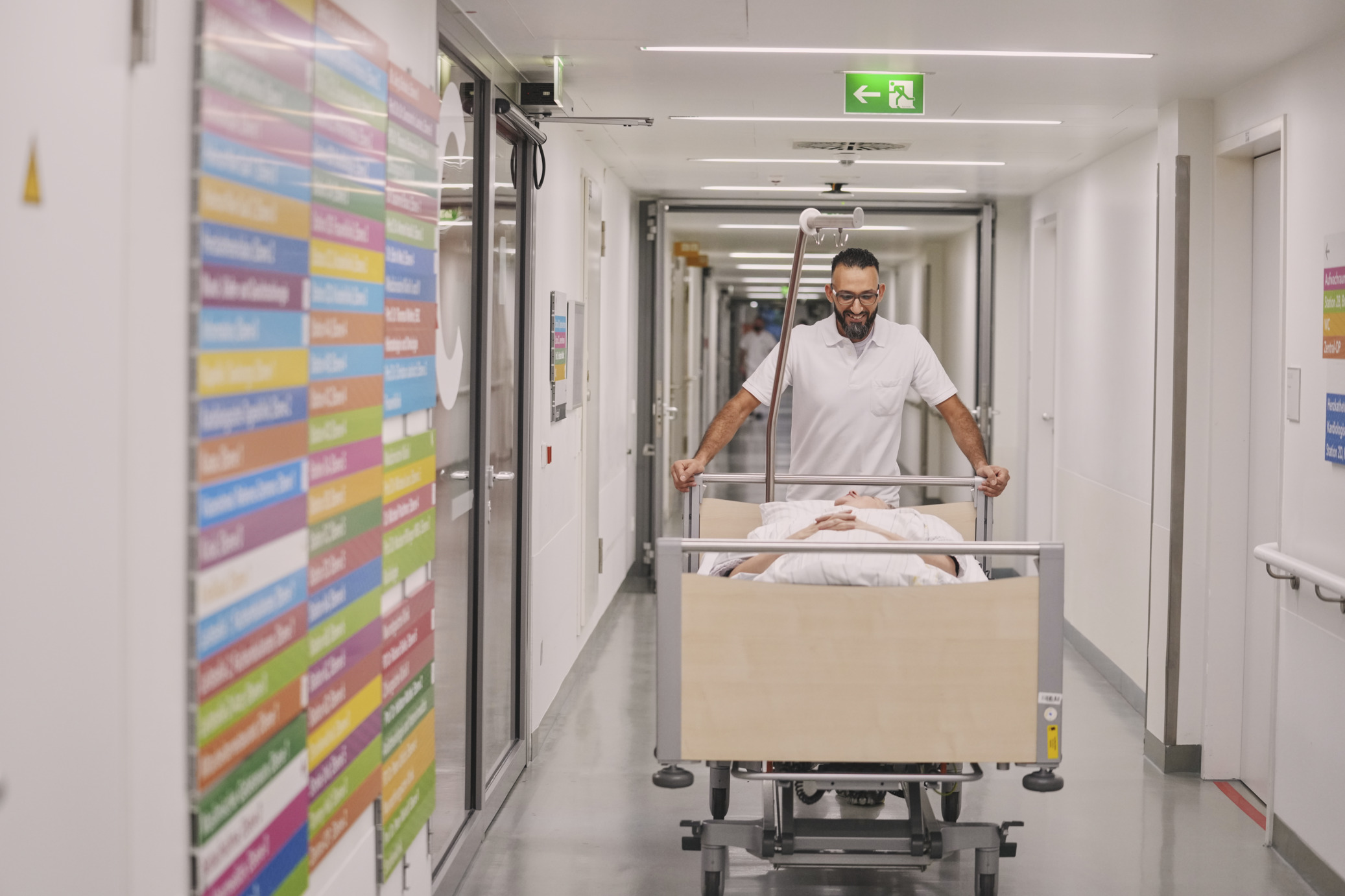 Mitarbeiter des Patiententransports schiebt Patient