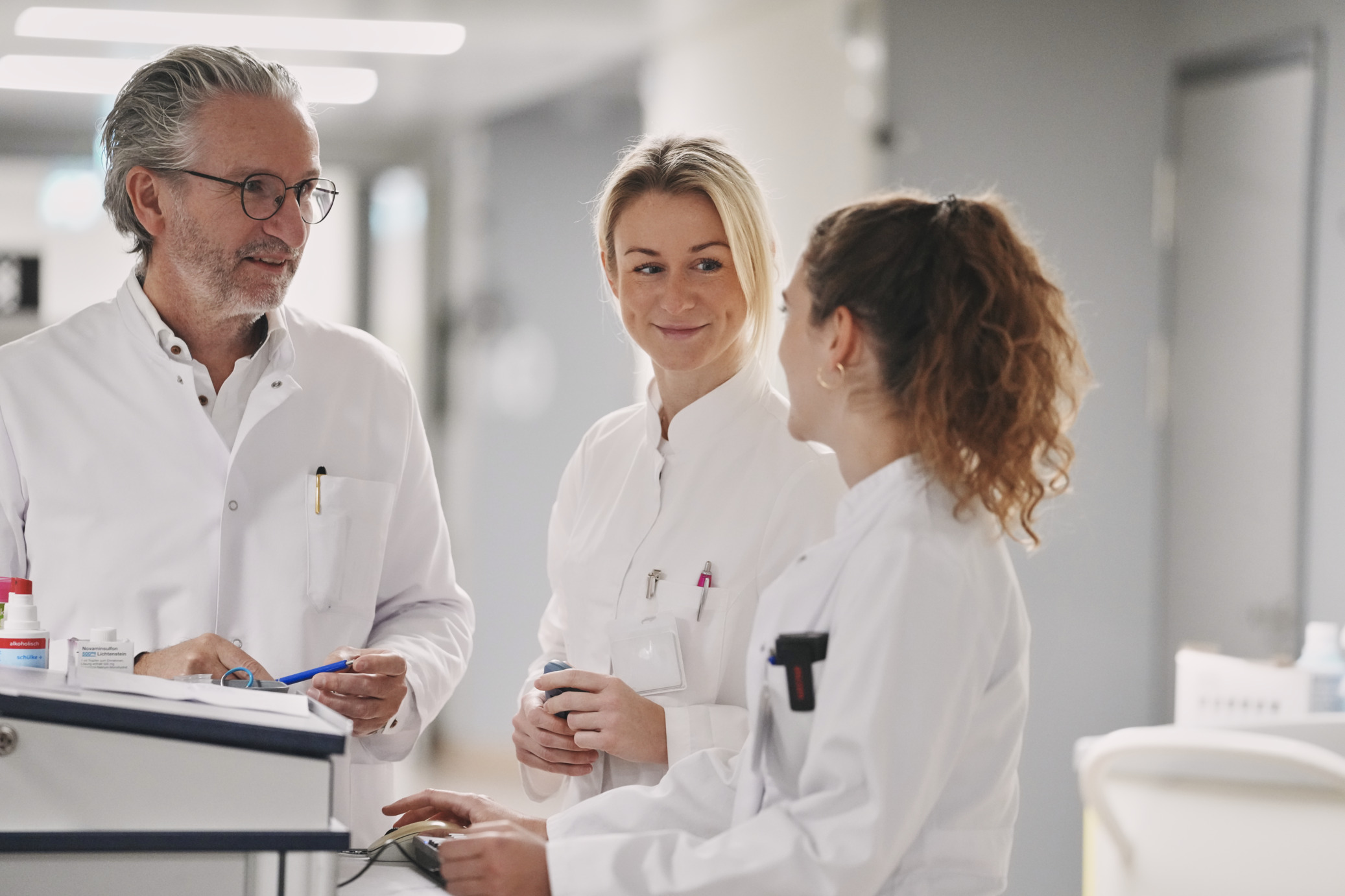  Ärzte besprechen sich auf dem Stationsflur