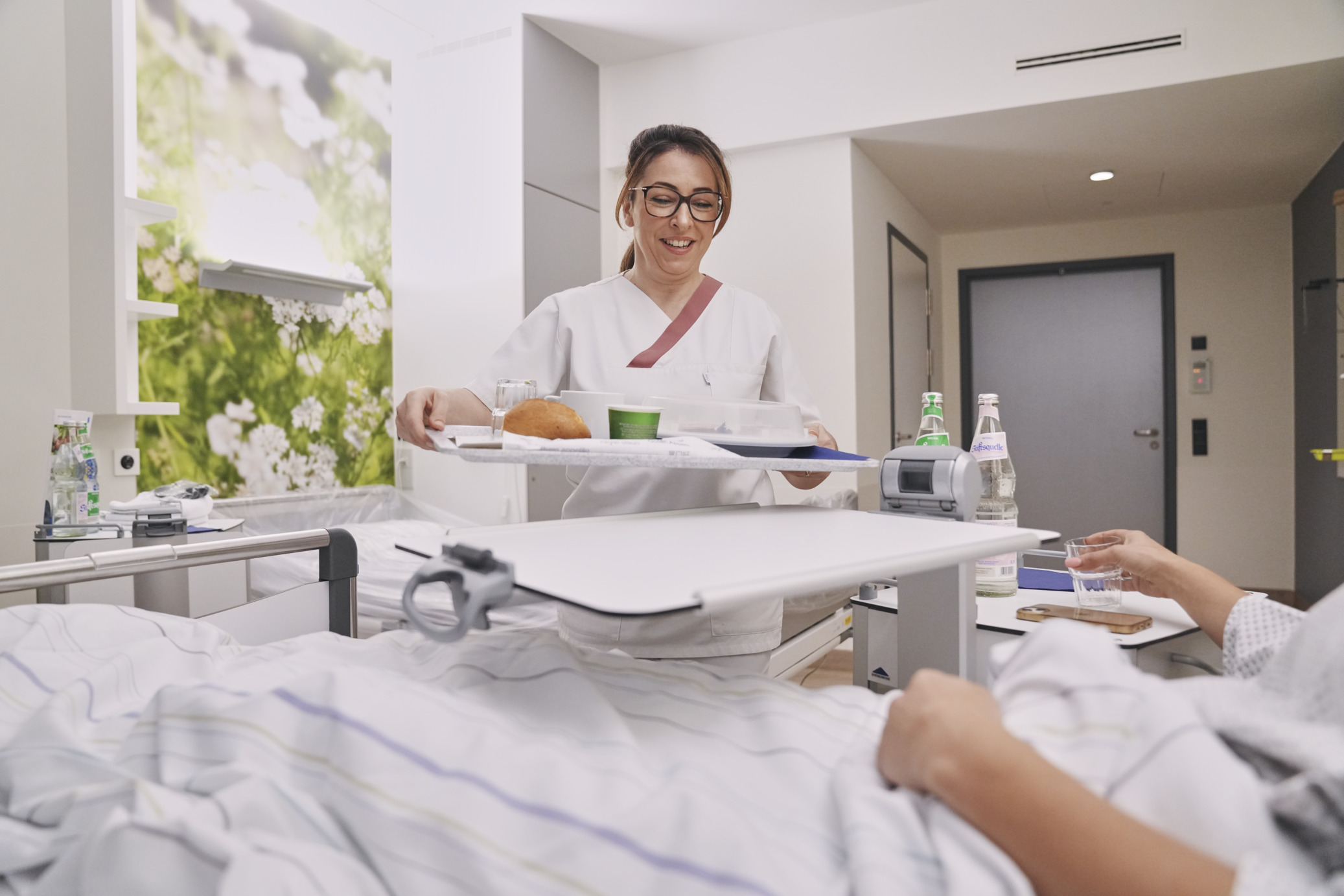  Patient bekommt Essenstablett und Getränk serviert