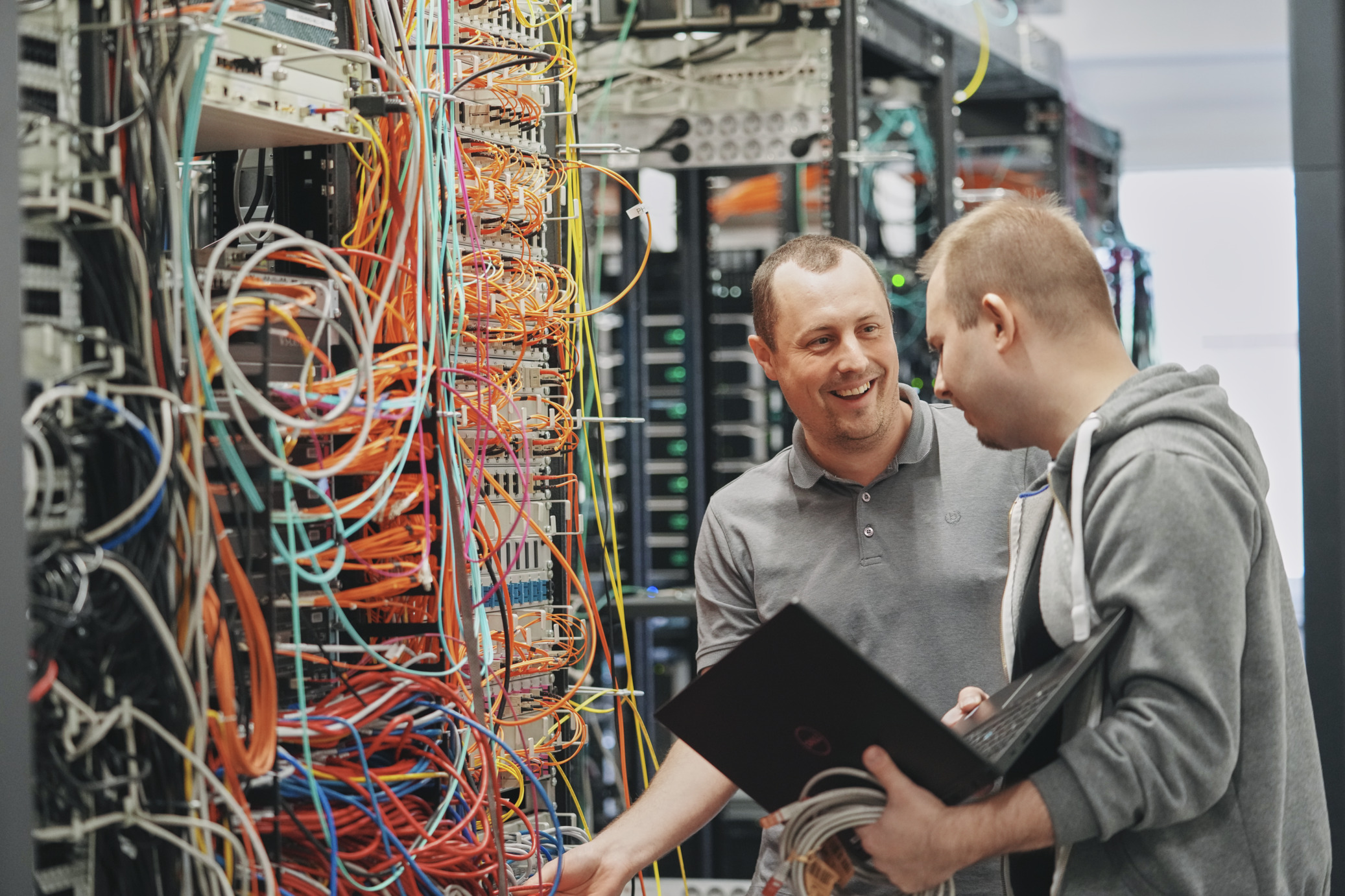 IT Mitarbeiter überprüfen Kabel im Serverraum