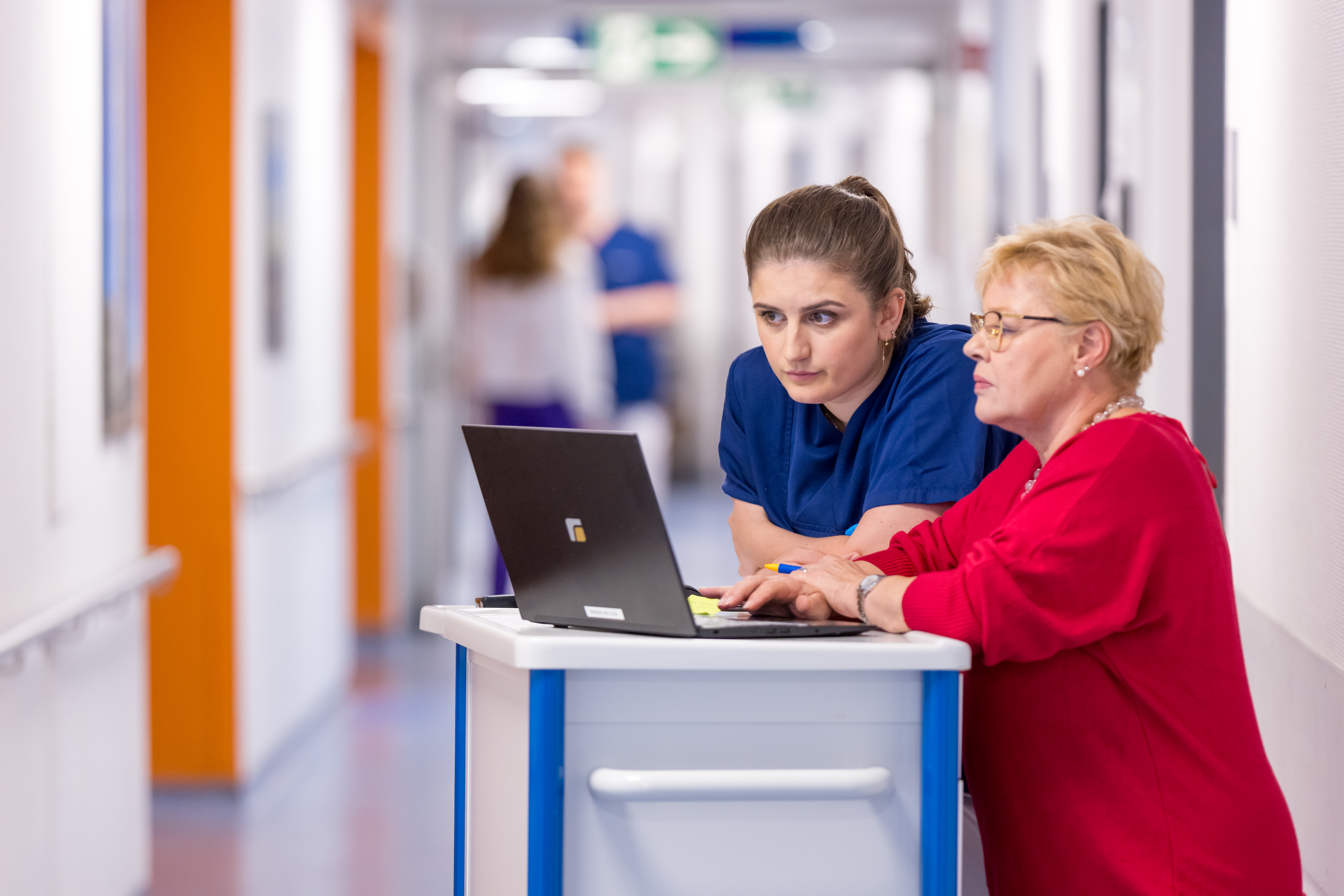 Eine Stationsleitung und Pflegefachkraft besprechen sich