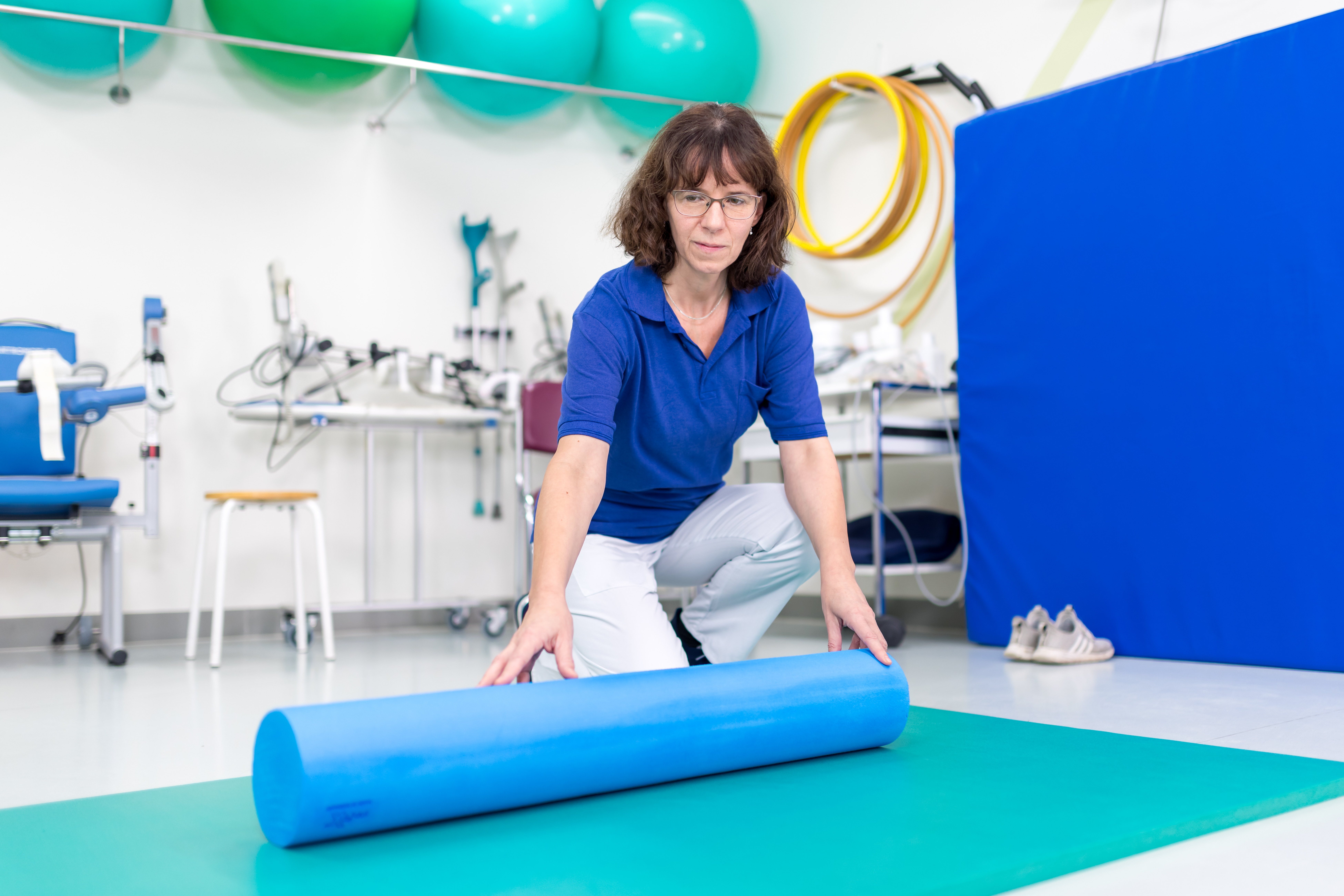 Physiotherapeuten rollt Matte aus