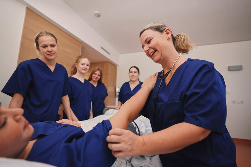 Das Bild zeigt fünf Mitarbeiterinnen im Gespräch mit einer Patientin.