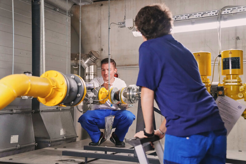 Das Bild zeigt zwei Mitarbeiter bei der Arbeit.