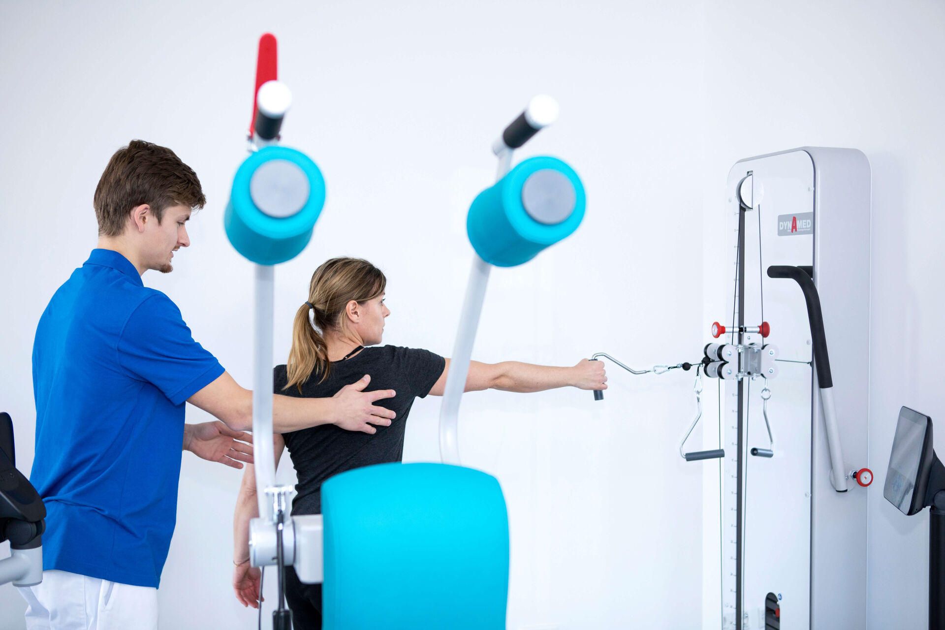 Das Bild zeigt einen Mitarbeiter bei der Behandlung einer Patientin.