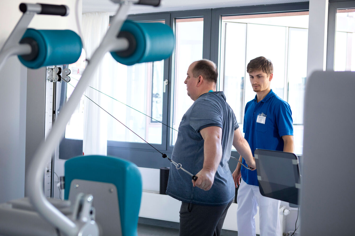 Das Bild zeigt einen Mitarbeiter bei der Behandlung eines Patienten.