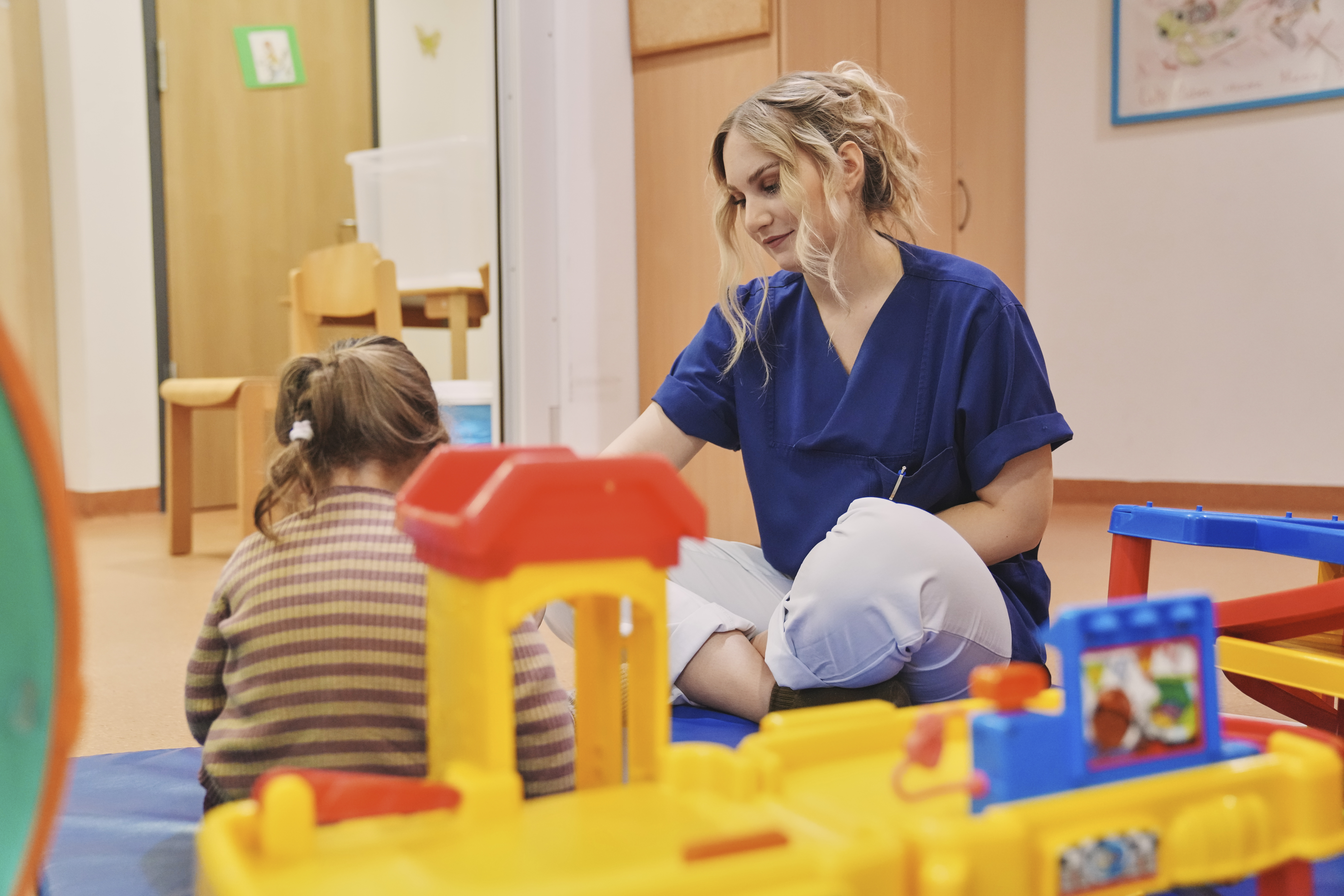 Erzieherin oder Erzieher betreut Kinder in einer Kinderbetreuungseinrichtung