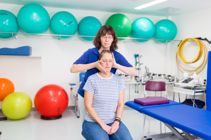 „Eine Therapeutin führt eine Massage bei einer Patientin im Rahmen Behandlung durch.