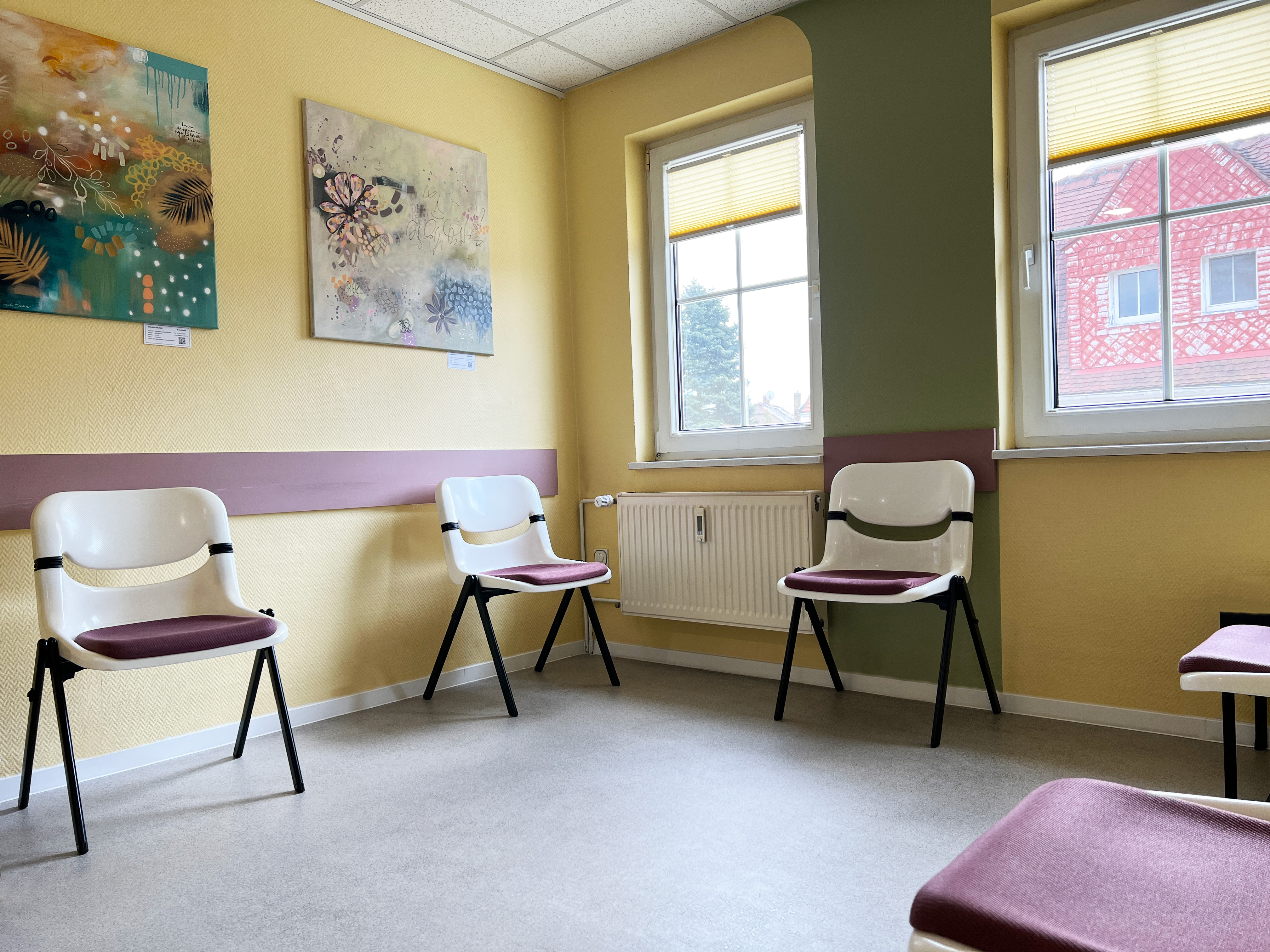 Foto vom Wartezimmer mit Stühlen und bunten Bildern an den Wänden im MVZ Brandis