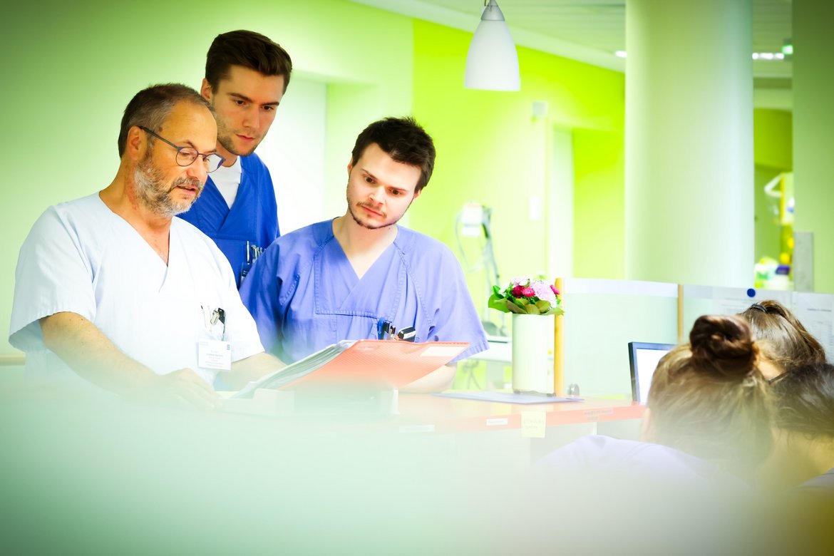 Dr. Volkmar Hanisch im Gespräch mit zwei jungen Medizinern.