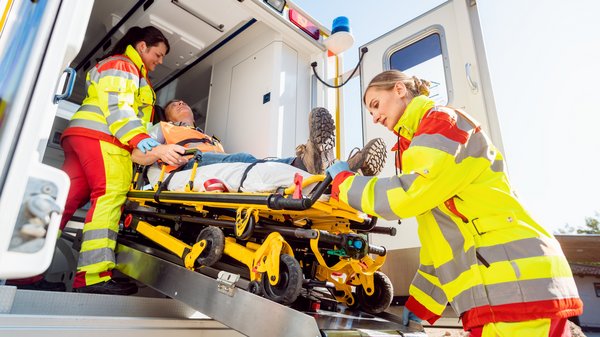 Rettungskräfte betreuen einen Patienten am Rettungswagen