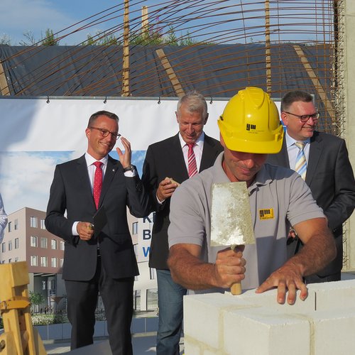 Ein Maurer beginnt mit dem Vermauern der Zeitkapsel.