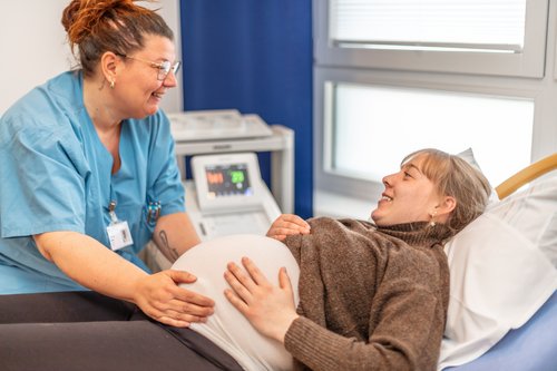 Hebamme mit schwangerer Frau Foto von einer Hebamme bei einer Untersuchung mit einer schwangeren Frau