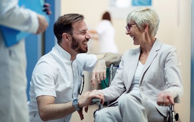 Seniorin im Rollstuhl mit Arzt