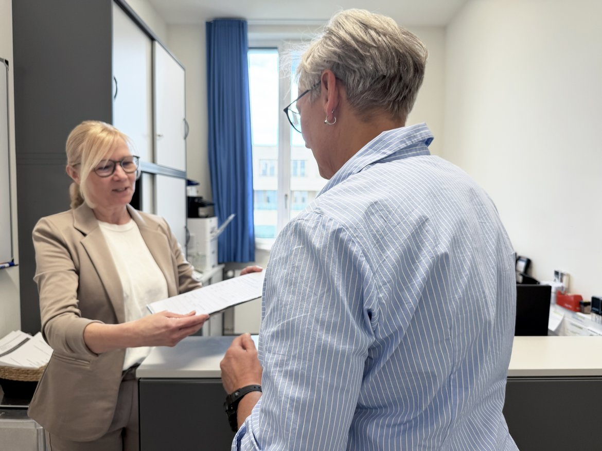 Empfang Sekretariat Frauenklinik Carola Gerstmann, Sekretärin der Frauenklinik, empfängt eine Patientin im Sekretariat und gibt ihr einen Patientenaufnahmebogen