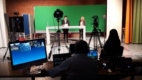 Fernsehstudio in dem zwei Personen stehen im Rahmen der Aufzeichnung Medizin im Dialog