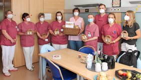 Pflegekräfte der Station Kardiologie 1 stehen im Schwesternzimmer und halten eine Box in der Hand