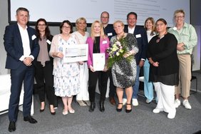 Preisträgerin Melanie Tulke (1. Reihe Mitte) mit der Jury-Vorsitzenden Dr. Heidemarie Haeske-Seeberg, (1. Reihe, 2. von r.), dem Sana-Vorstand und dem Führungsteam der Regio Kliniken.