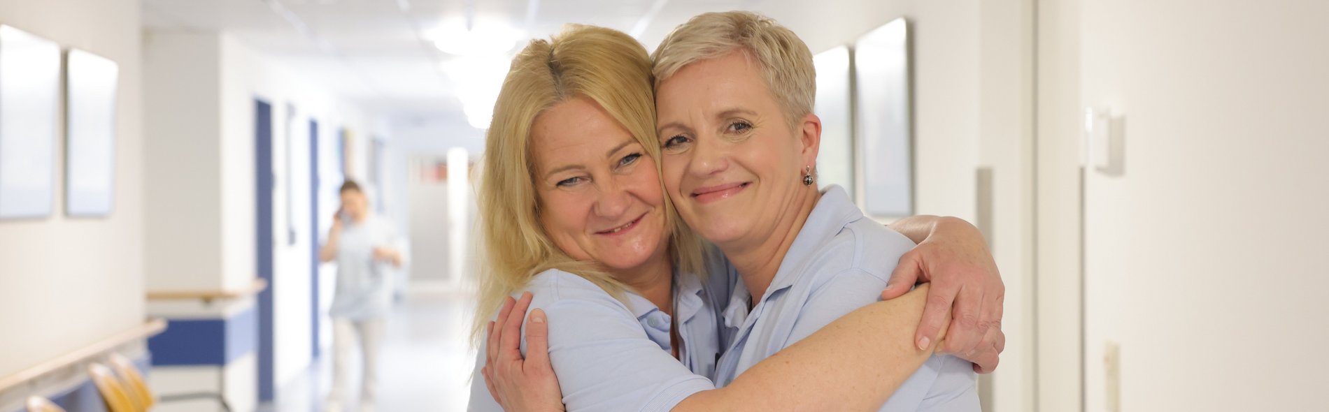 Karen Mettke umarmt Birgit Seeber-Heinrich. Beide sind seit 30 Jahren Mitarbeiterinnen im Sana-Herzzentrum Cottbus.