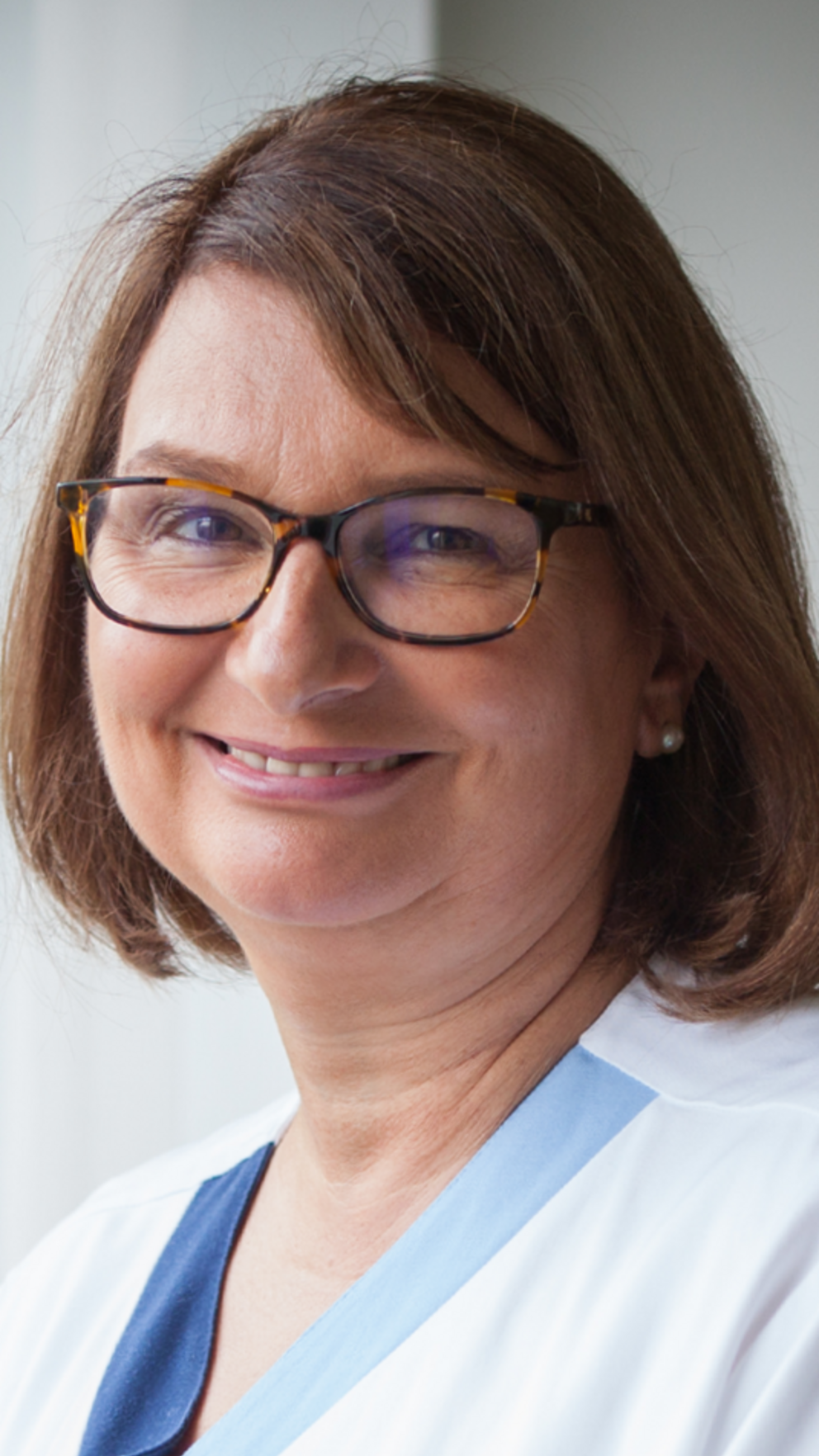 Portraitfoto von einer Mitarbeiterin vor dem Fenster