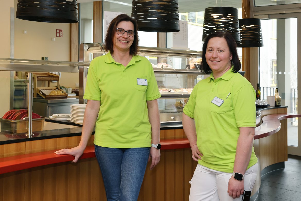 Bistroleitung Beate Käschel und Kristina Spiegel Zwei Frauen in grünem Shirt stehen im Bistro