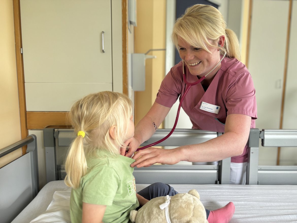 Bild mit Oberärztin Dr. med. Linda Zimmerling, sie untersucht eine kleine Patientin