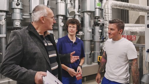 Das Foto zeigt eine Besprechung von Ingenieuren im Heizungskeller.