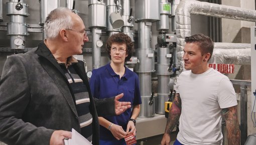 Das Foto zeigt eine Besprechung von Ingenieuren im Heizungskeller.