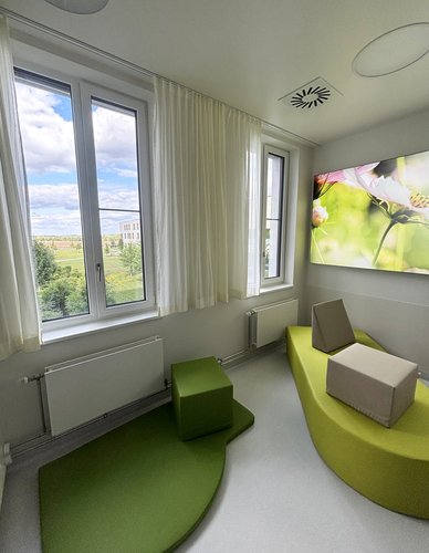 Ausschnitt von Kreißsaal 2 im Geburtszentrum Biberach, in grün gehalten, mit Be-up Modulen sowie Ausblick ins Grüne