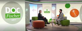 Prof. Flachenecker und ein Moderator sitzen sich auf einem Sofa im Fernsehstudio der Sendung Doc Fischer gegenüber