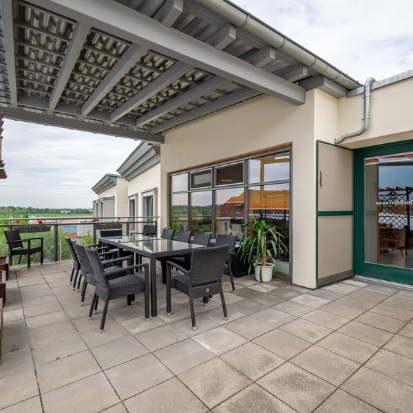 Großzügige Dachterrasse mit modernen Sitzgelegenheiten und Sonnenschutz.  