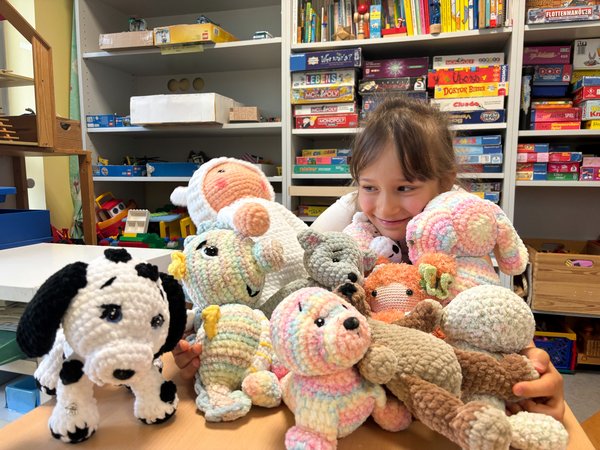 Bild das ein Mädchen mit Kuscheltieren im Spielzimmer in der Klinik für Kinder und Jugendliche zeigt.