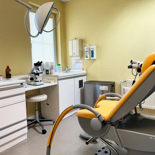 Untersuchungszimmer mit gynäkologischem Stuhl und Untersuchungsausrüstung.