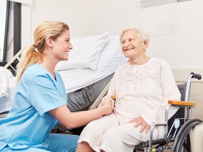 Seniorin im Rollstuhl mit Pflegerin