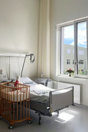 Bett und Baby-Beistellbett in einem Patientenzimmer im Geburtszentrum Biberach 
