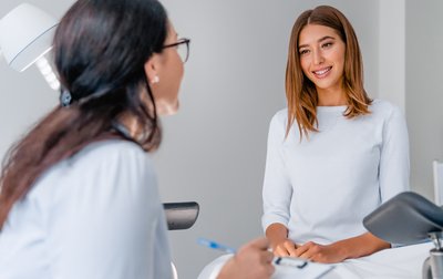 Eine Ärztin spricht in ihrer Praxis mit einer Patientin. 