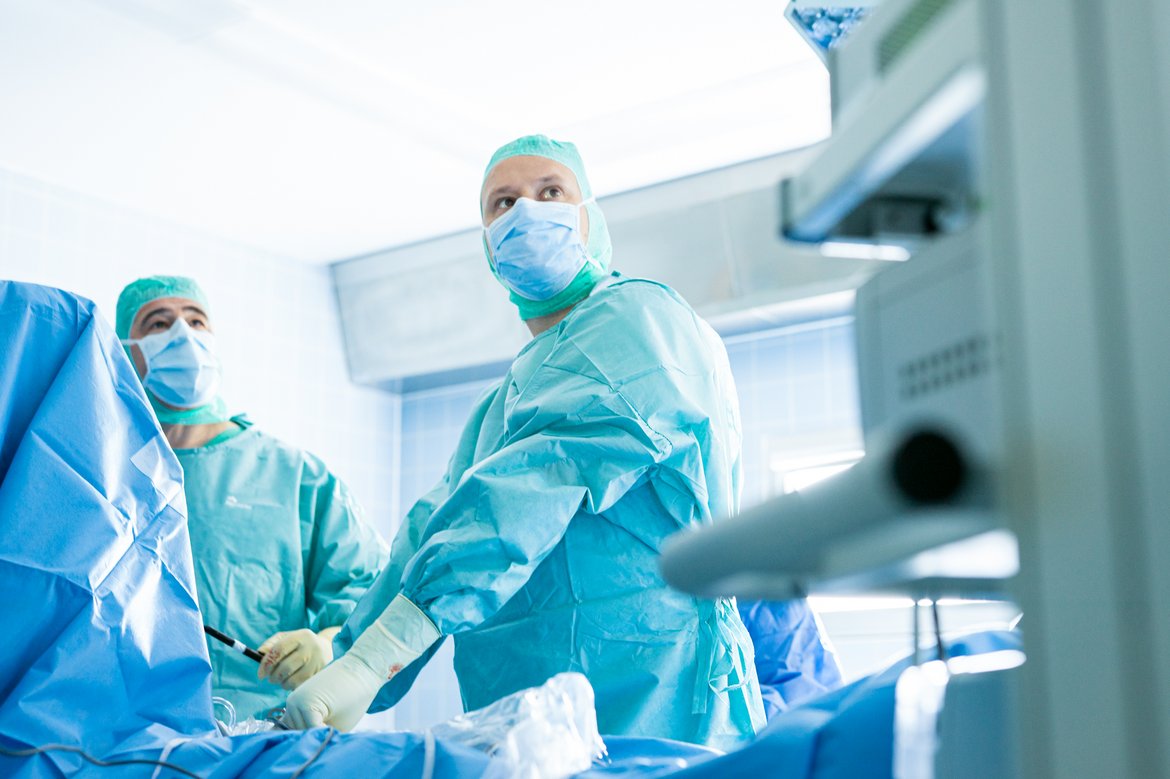 Surgeons operate on patient in modern operating room equipped with innovative medical technology.