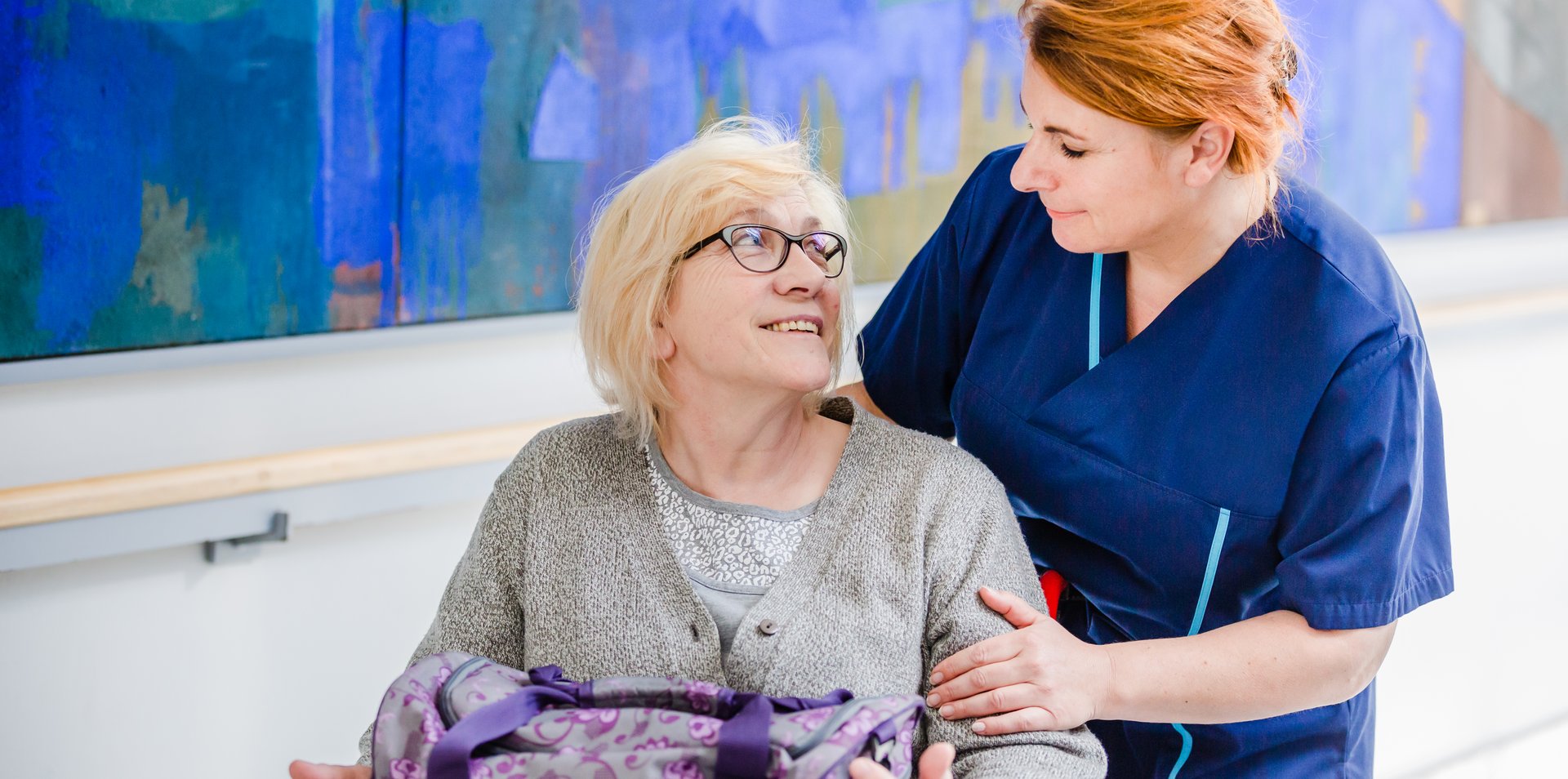 Patientin im Rollstuhl mit Pflegerin