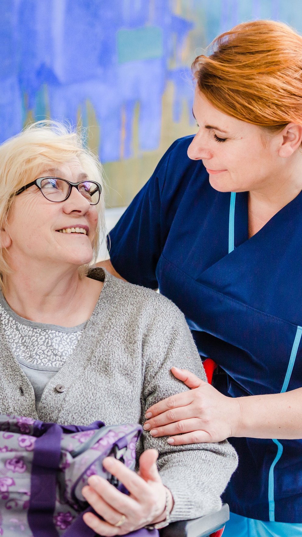 Patientin im Rollstuhl mit Pflegerin