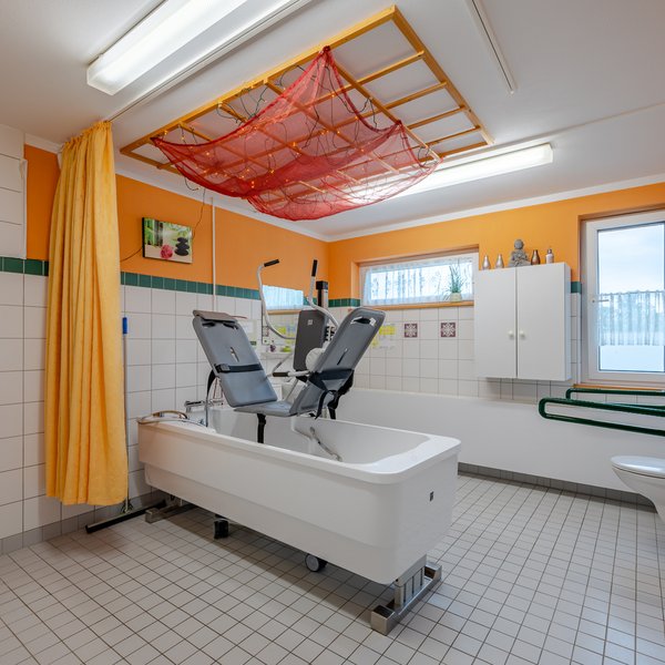 Pflegebad mit Liegebadewanne und barrierefreien Zugängen.